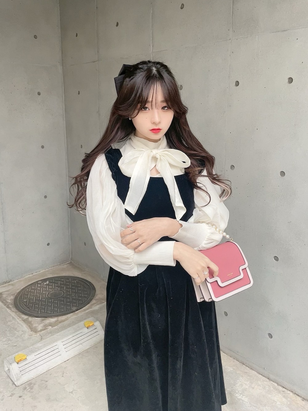 ブラック系のパンプス、ブラック系のジャンパースカート、ホワイト系のシャツ/ブラウスを着用したレディースの冬コーディネートの4枚目の写真