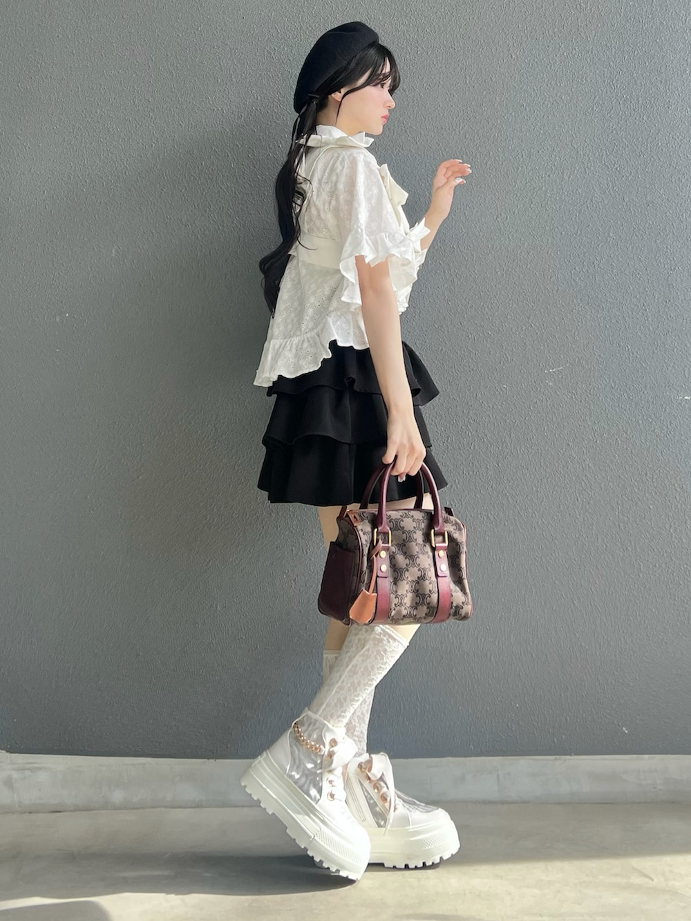 ブラック系のスカート、ホワイト系のベスト、ホワイト系のシャツ/ブラウスを着用したレディースの春コーディネートの3枚目の写真