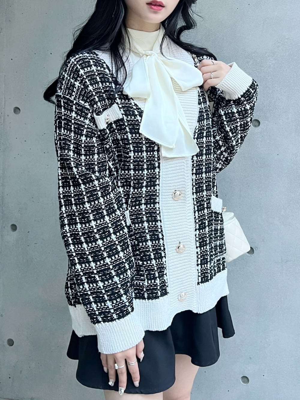 ブラック系のカーディガン/ボレロ、ホワイト系のシャツ/ブラウス、ブラック系のスカートを着用したレディースの秋コーディネートの4枚目の写真