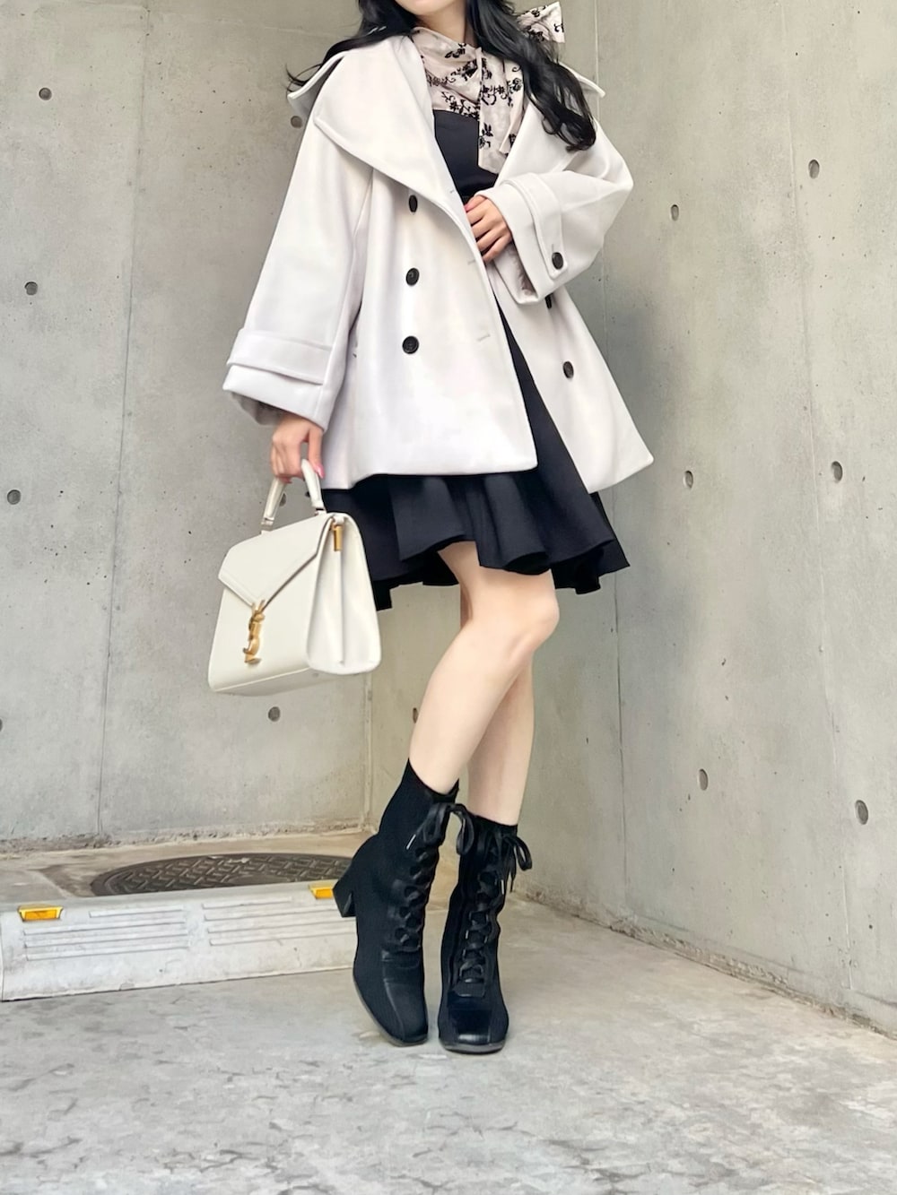 ブラック系のシャツ/ブラウス、ホワイト系のジャケット/アウター、ブラック系のジャンパースカートを着用したレディースの秋コーディネートの4枚目の写真