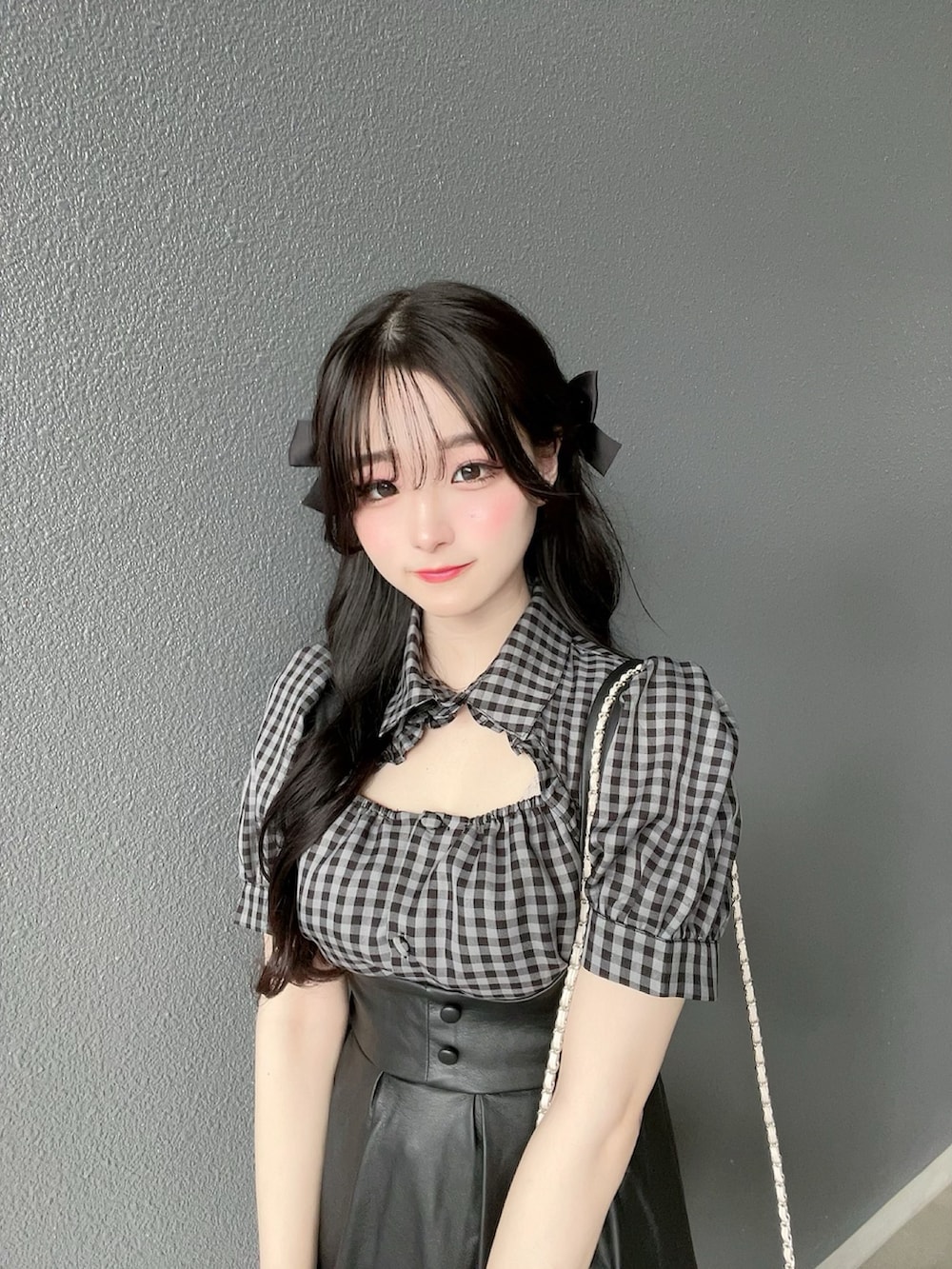 ホワイト系のトップス、ブラック系のジャンパースカート、ブラック系のシューズを着用したレディースの夏コーディネートの5枚目の写真