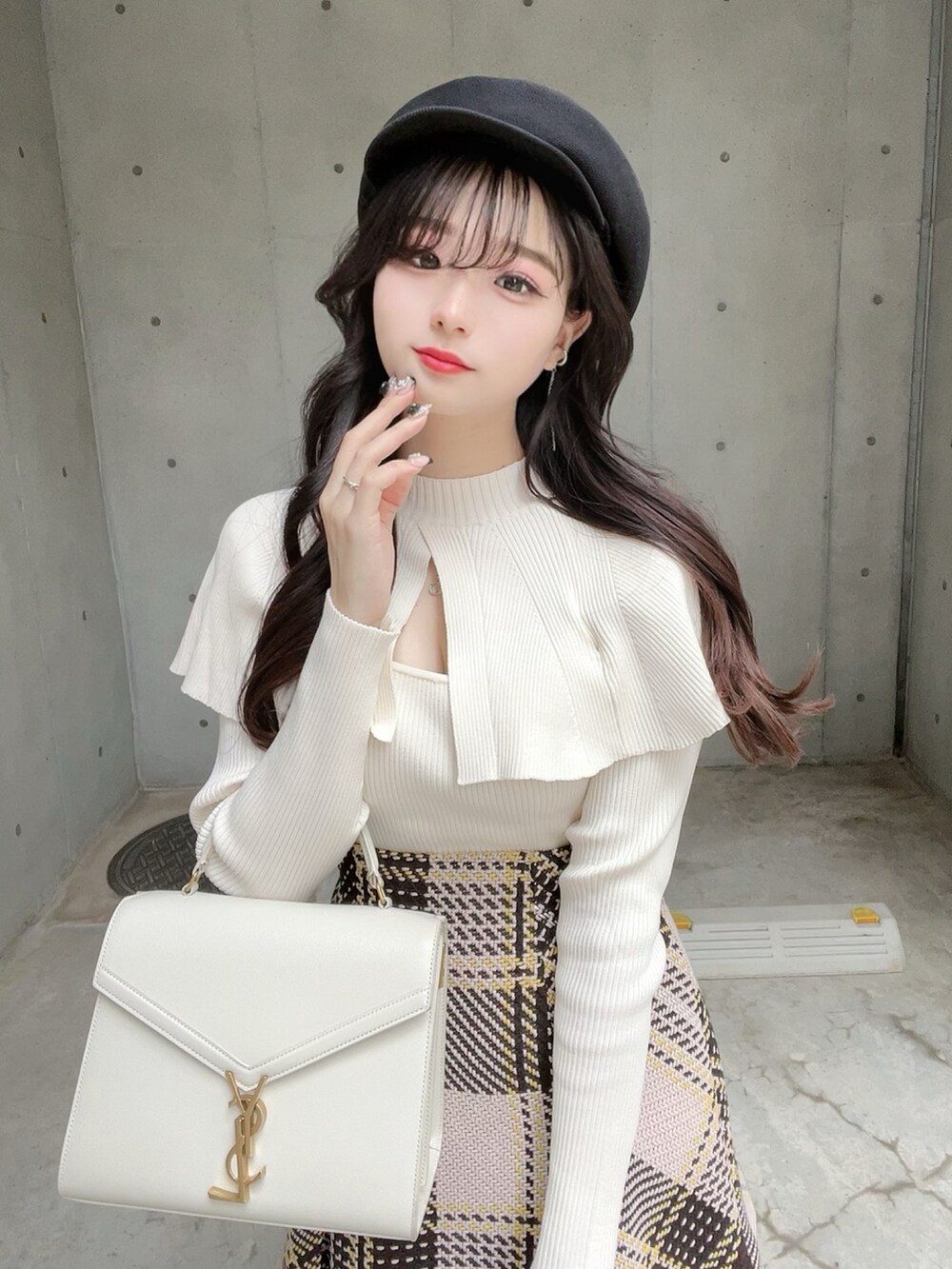 ホワイト系のニット/セーター、ベージュ系のスカート、ブラック系のブーツを着用したレディースの秋コーディネートの5枚目の写真