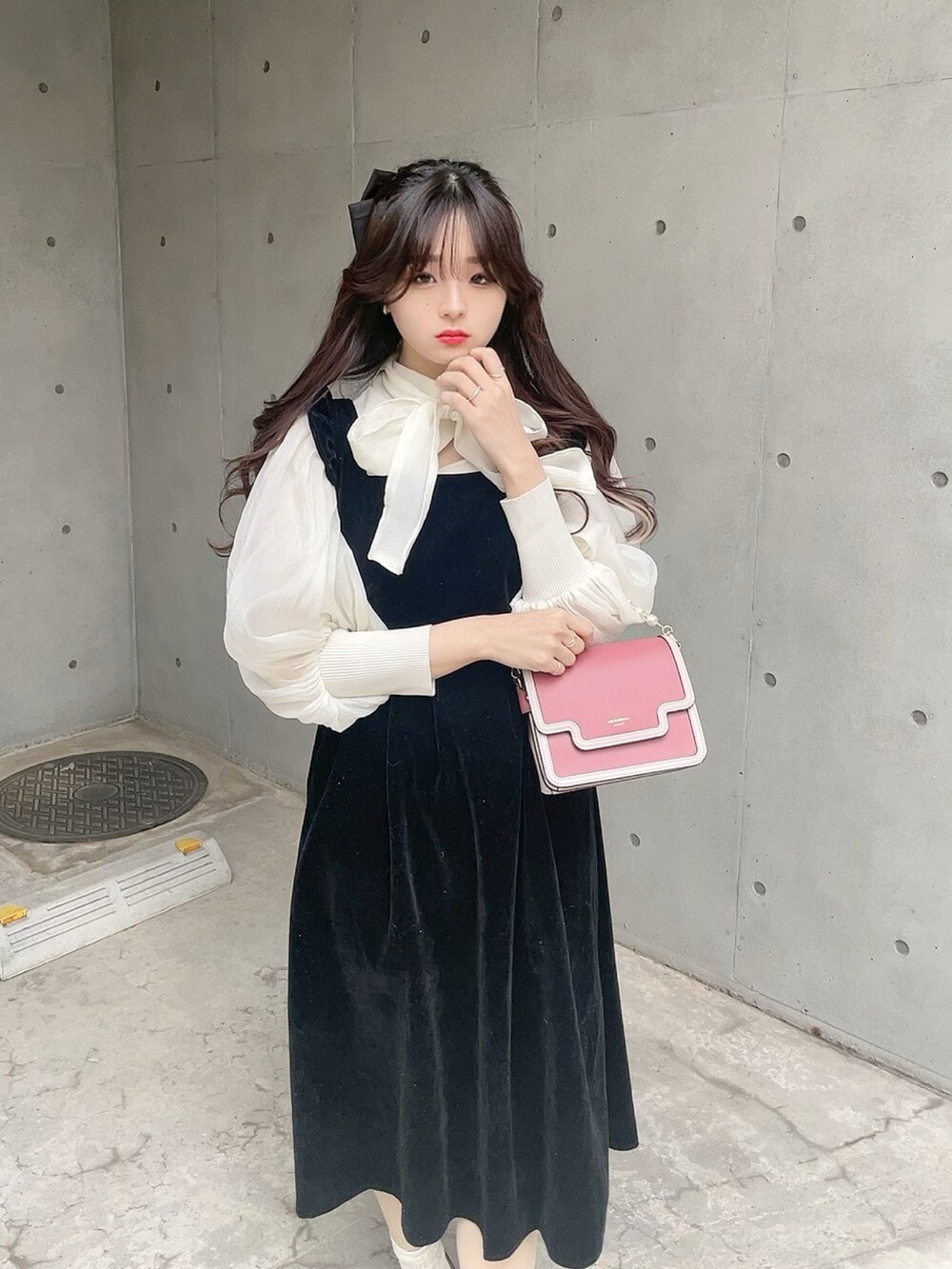 ブラック系のパンプス、ブラック系のジャンパースカート、ホワイト系のシャツ/ブラウスを着用したレディースの冬コーディネートの5枚目の写真