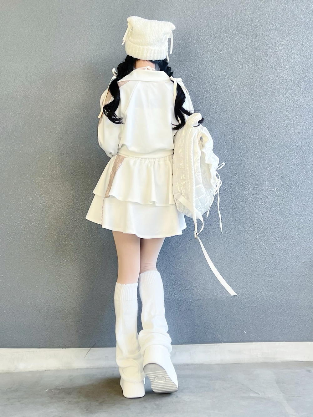 ホワイト系のシューズ、ホワイト系のジャージ、ホワイト系のスカートを着用したレディースの冬コーディネートの3枚目の写真