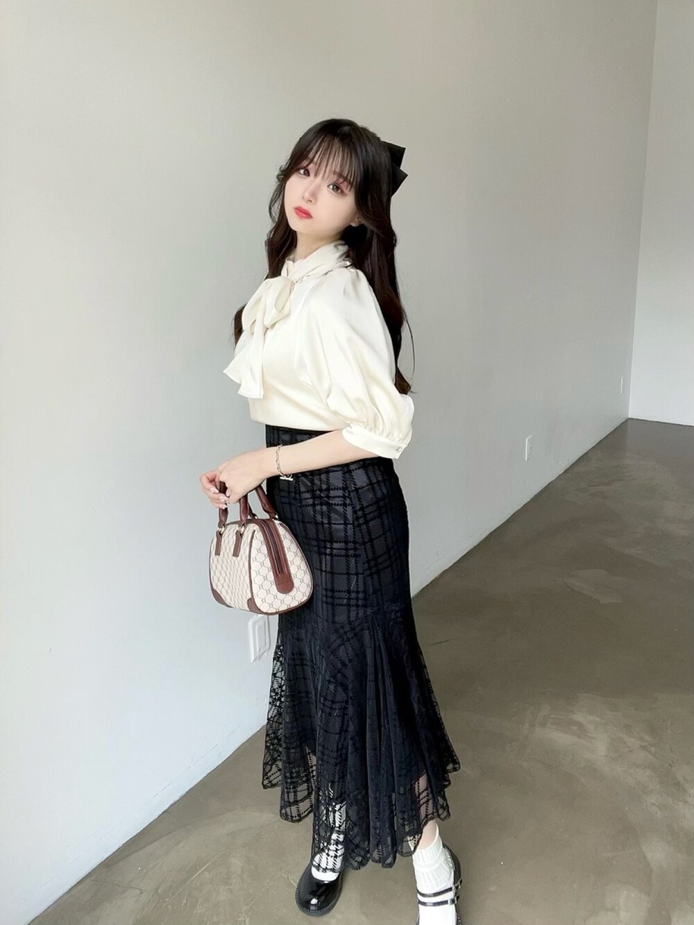 ベージュ系のシャツ/ブラウス、ブラック系のスカートを着用したレディースの夏コーディネートの3枚目の写真