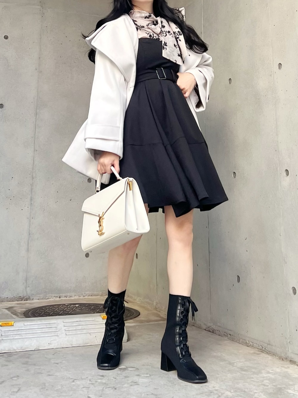 ブラック系のシャツ/ブラウス、ホワイト系のジャケット/アウター、ブラック系のジャンパースカートを着用したレディースの秋コーディネートの5枚目の写真