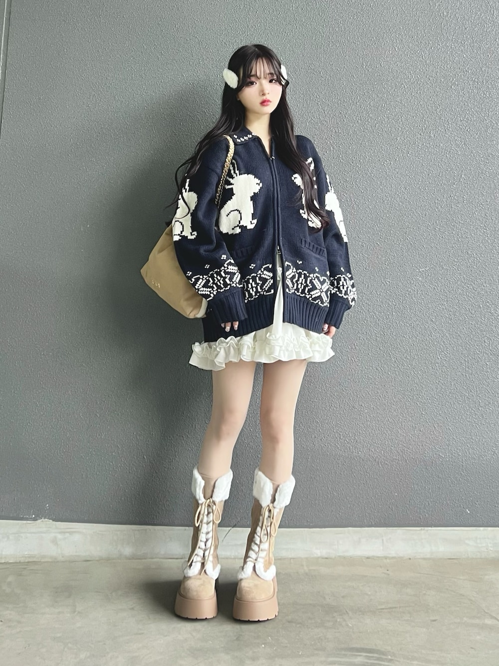 ベージュ系のトートバッグ、ブルー系のニット/セーター、ホワイト系のスカートを着用したレディースの秋コーディネートの2枚目の写真