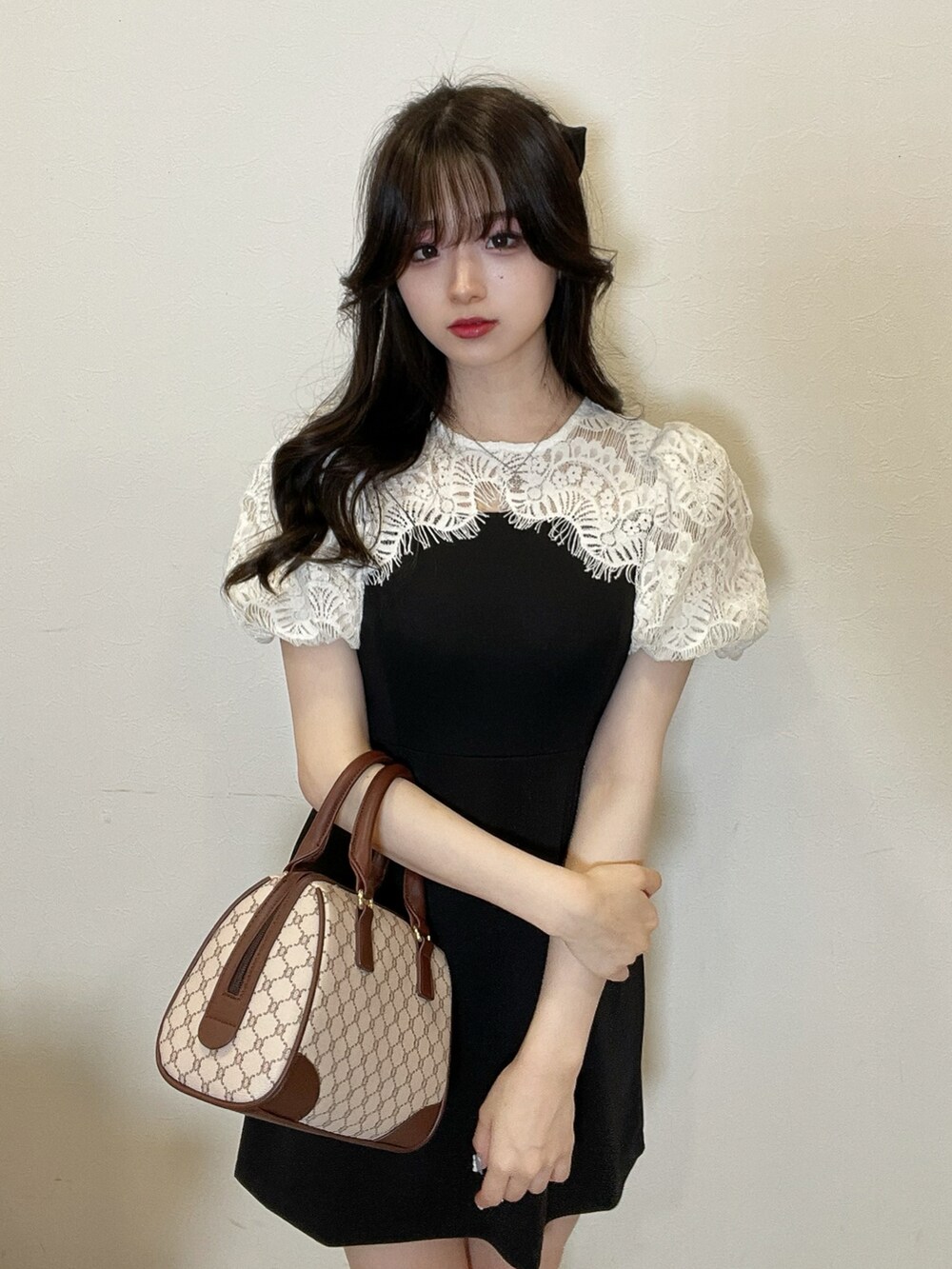 ブラック系のワンピース、ベージュ系のバッグを着用したレディースの夏コーディネートの2枚目の写真
