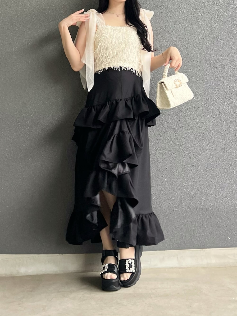 ブラック系のスカート、ホワイト系のその他トップス、ブラック系のサンダルを着用したレディースの夏コーディネートの4枚目の写真