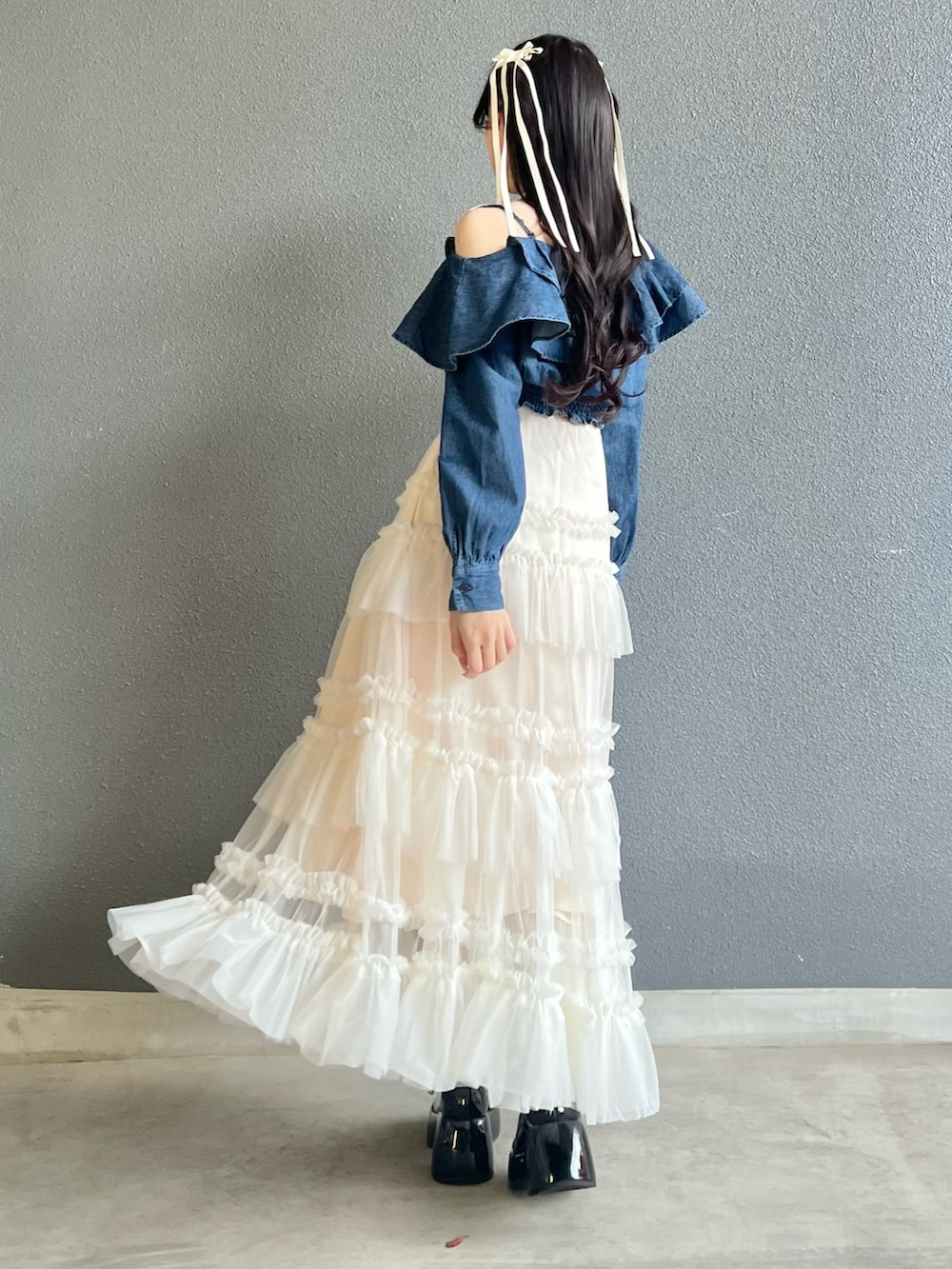 ブラック系のパンプス、ホワイト系のスカート、ピンク系のバッグを着用したレディースの春コーディネートの3枚目の写真