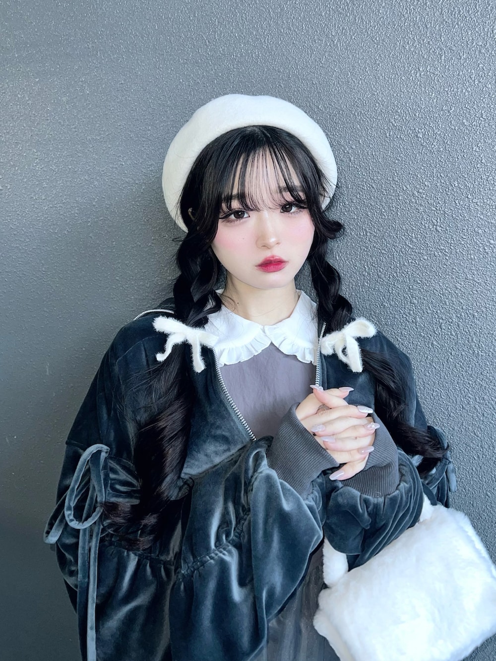 ブラック系のパンプス、グレー系のワンピース、ホワイト系のバッグを着用したレディースの冬コーディネートの5枚目の写真