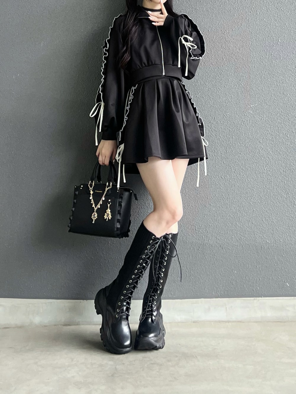 ブラック系のジャージ、ブラック系のスカート、ブラック系のバッグを着用したレディースの秋コーディネートの3枚目の写真