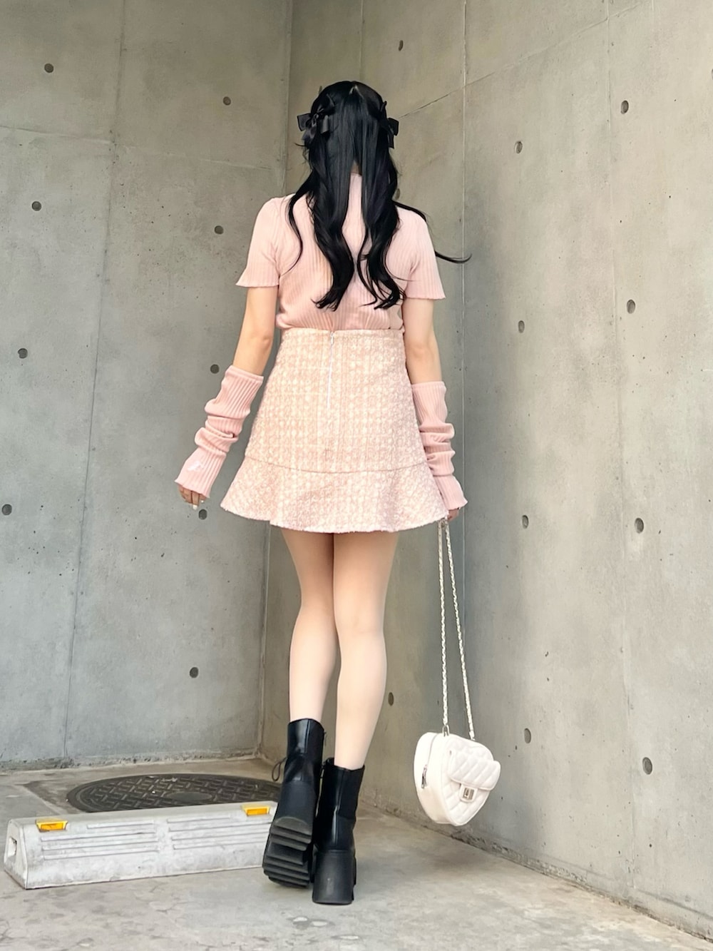 ピンク系のスカート、ピンク系のTシャツ/カットソー、ブラック系のブーツを着用したレディースの春コーディネートの5枚目の写真