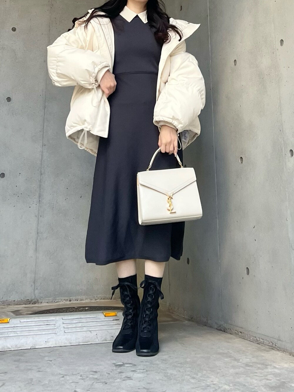 グレー系のワンピース、ホワイト系のダウンジャケット/コートを着用したレディースの冬コーディネートの4枚目の写真