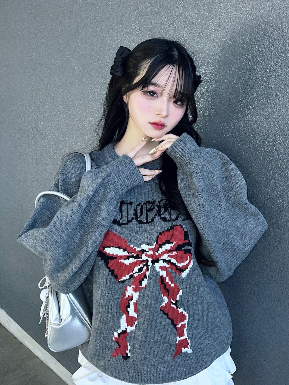 グレー系のニット/セーター、ホワイト系のパンツ、シルバー系のバッグを着用したレディースの冬コーディネートの5枚目の写真