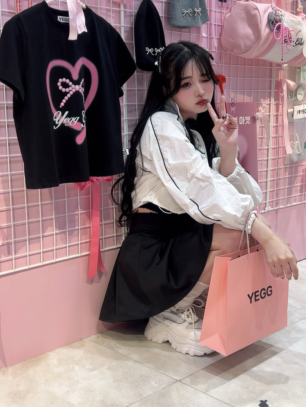 ホワイト系のベスト、ブラック系のスカート、ブラック系のバッグを着用したレディースの夏コーディネートの2枚目の写真