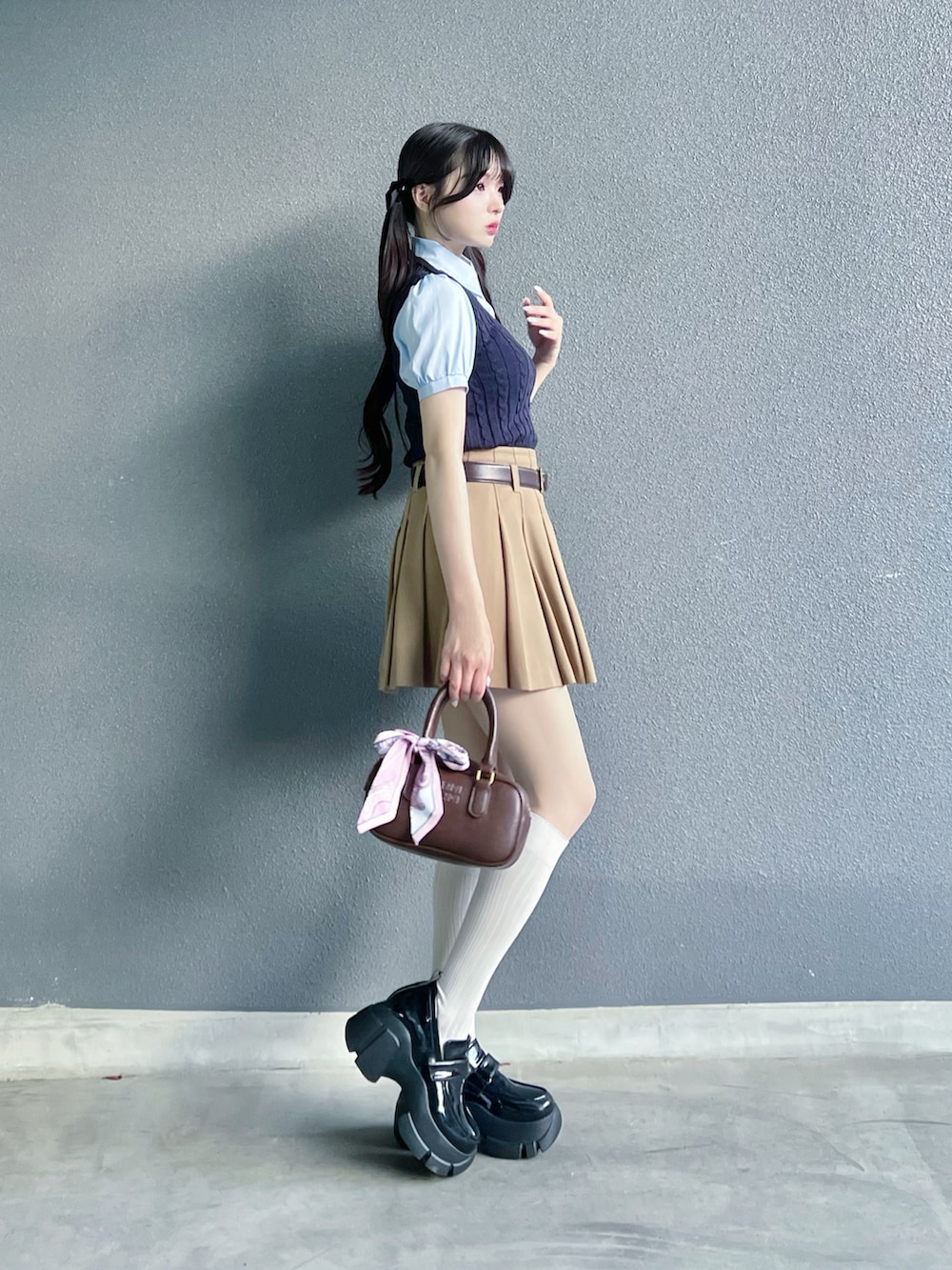 ベージュ系のその他パンツ、ブルー系のトップス、ブラウン系のバッグを着用したレディースの夏コーディネートの2枚目の写真