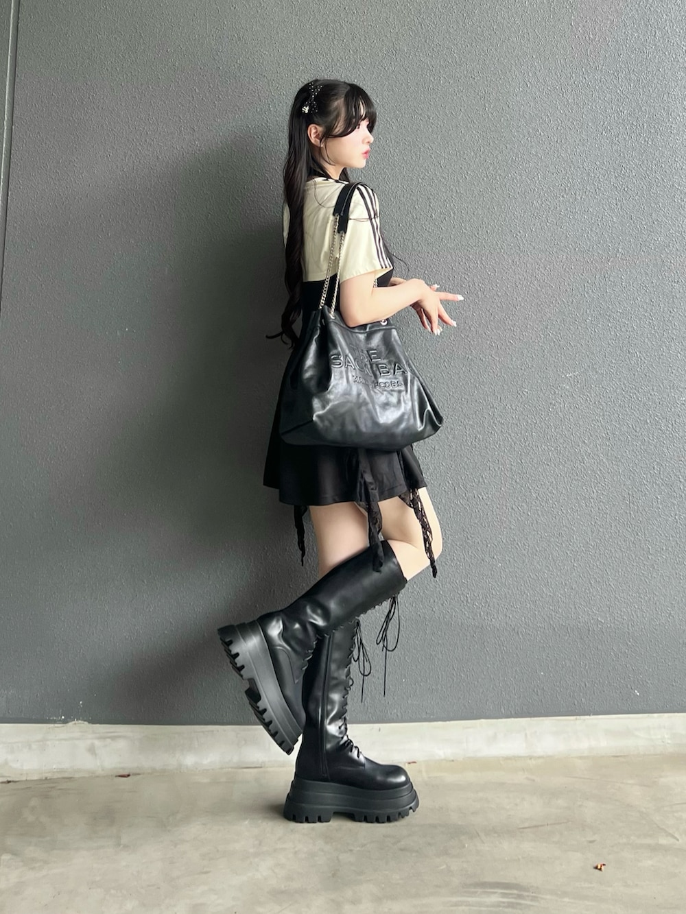 ホワイト系のTシャツ/カットソー、ブラック系のブーツ、ブラック系のショルダーバッグを着用したレディースの夏コーディネートの2枚目の写真