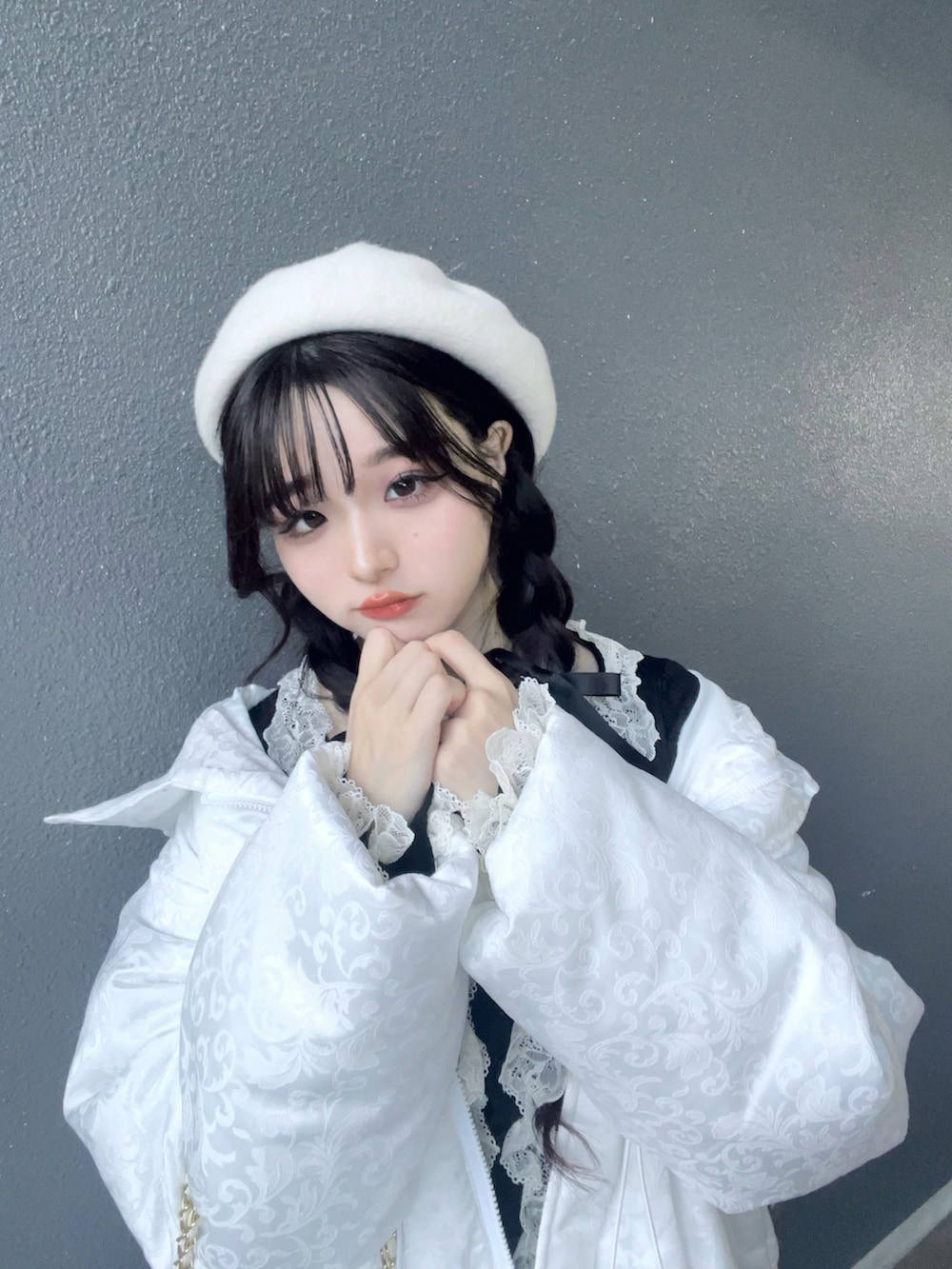 ブラック系のスカート、ブラック系のトップス、ホワイト系のバッグを着用したレディースの冬コーディネートの5枚目の写真