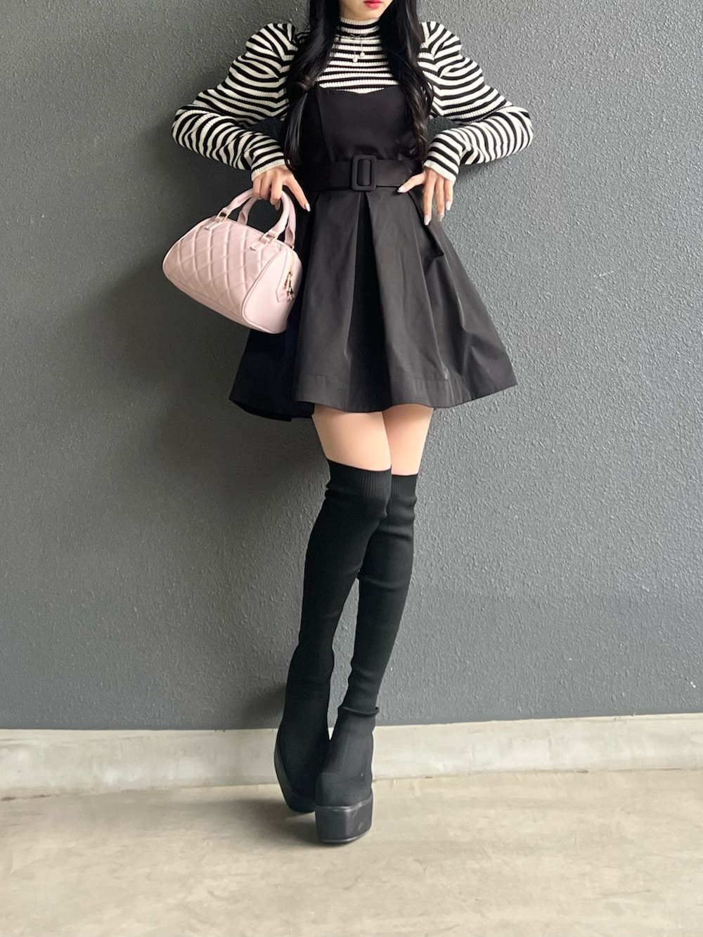 ブラック系のスカート、ブラック系のトップス、ブラック系のブーツを着用したレディースの冬コーディネートの5枚目の写真