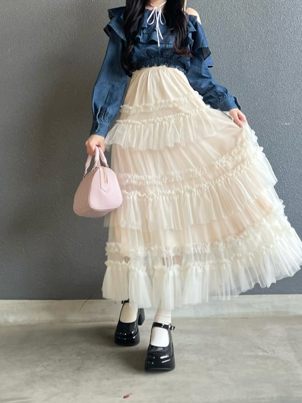 ブラック系のパンプス、ホワイト系のスカート、ピンク系のバッグを着用したレディースの春コーディネートの4枚目の写真