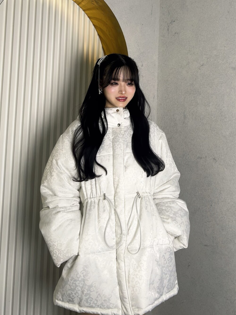 ホワイト系のジャケット/アウター、ホワイト系のバッグ、ブラック系のブーツを着用したレディースの冬コーディネートの5枚目の写真