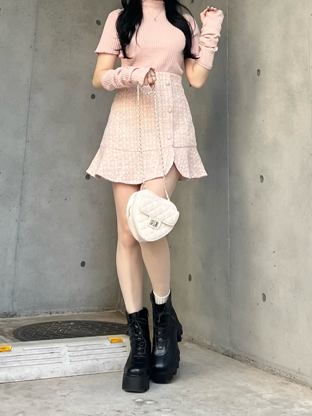 ピンク系のスカート、ピンク系のTシャツ/カットソー、ブラック系のブーツを着用したレディースの春コーディネートの3枚目の写真