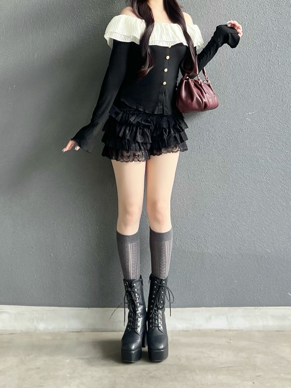 ブラック系のブーツ、ブラック系のトップス、ブラック系のパンツを着用したレディースの秋コーディネートの4枚目の写真