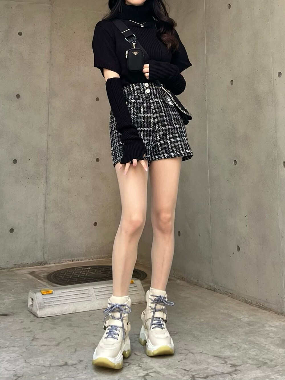 ブラック系のニット/セーター、ホワイト系のその他パンツを着用したレディースの春コーディネートの2枚目の写真