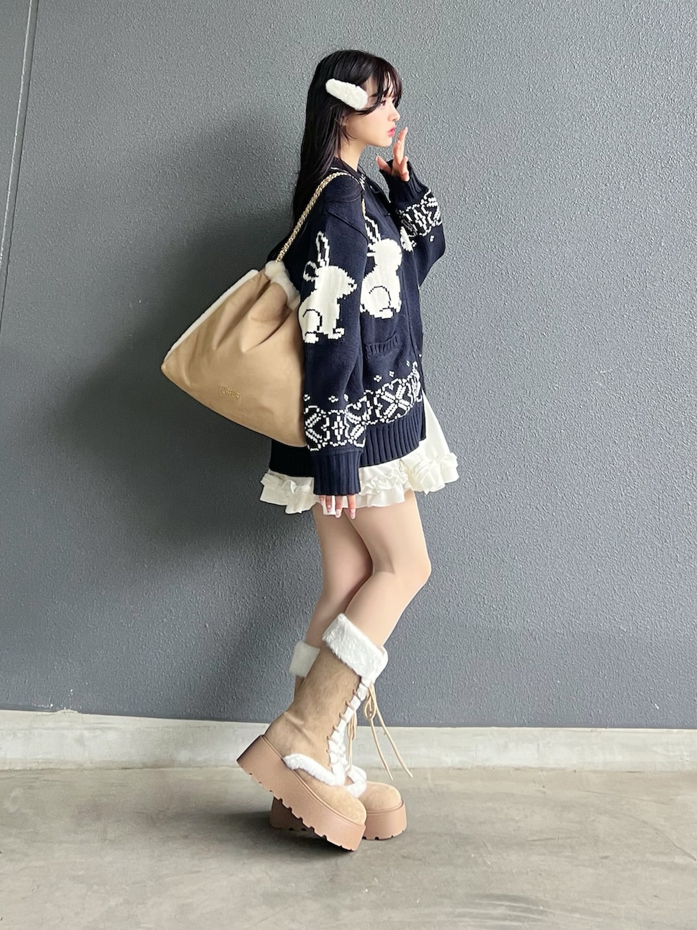 ベージュ系のトートバッグ、ブルー系のニット/セーター、ホワイト系のスカートを着用したレディースの秋コーディネートの3枚目の写真