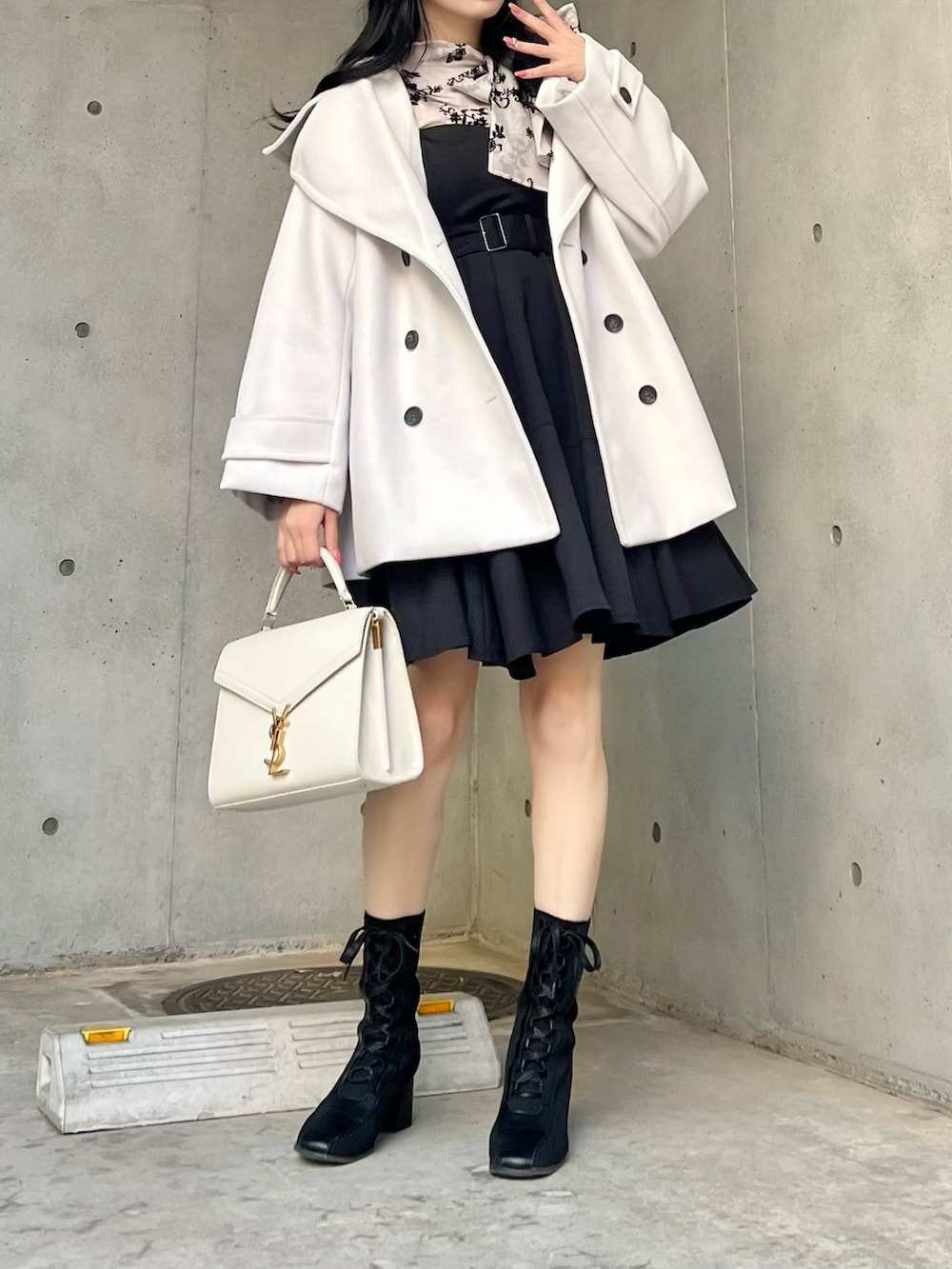 ブラック系のシャツ/ブラウス、ホワイト系のジャケット/アウター、ブラック系のジャンパースカートを着用したレディースの秋コーディネートの3枚目の写真