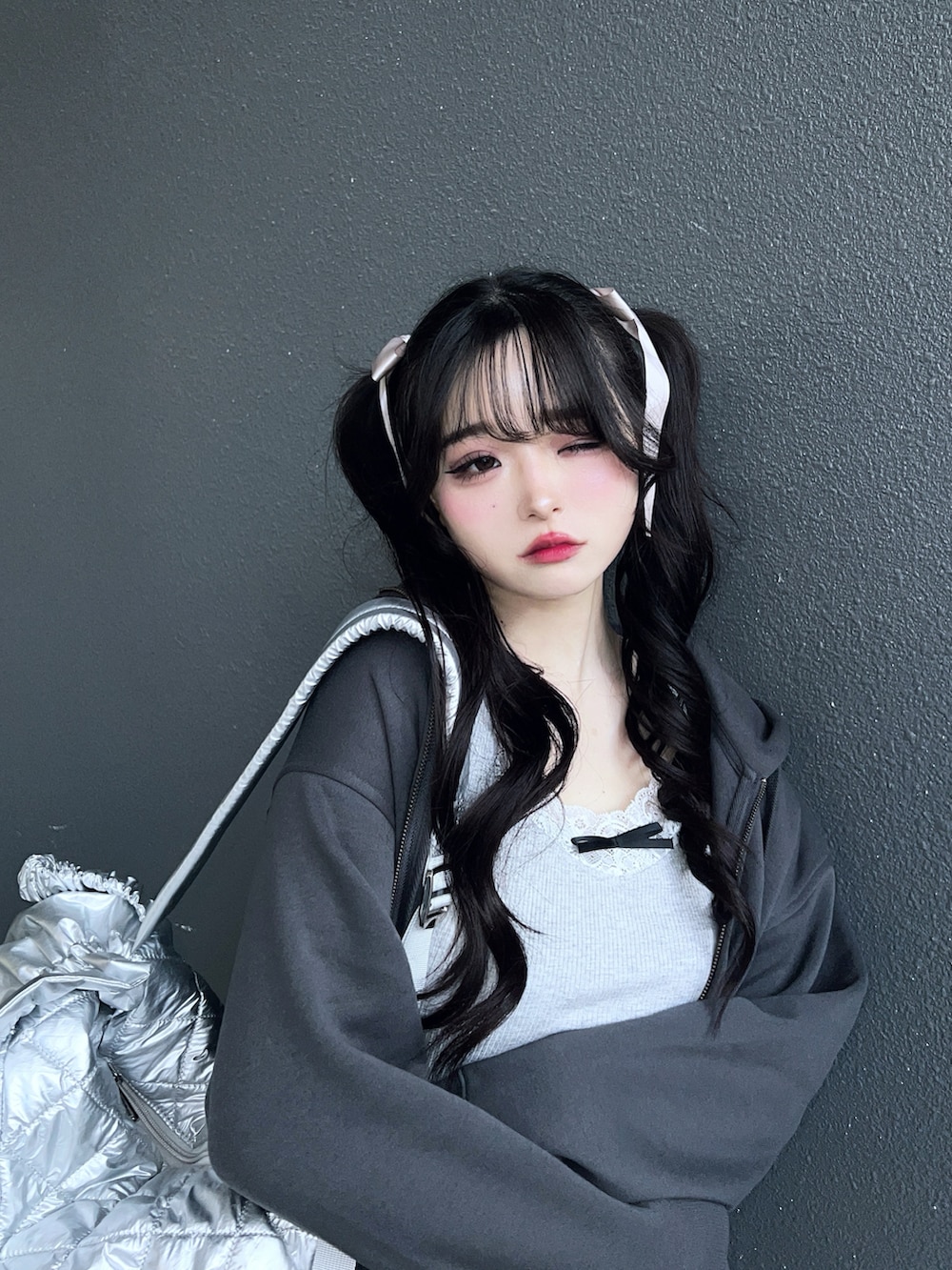 グレー系のパーカー、ブラック系のブーツ、ブラック系のスカートを着用したレディースの冬コーディネートの5枚目の写真