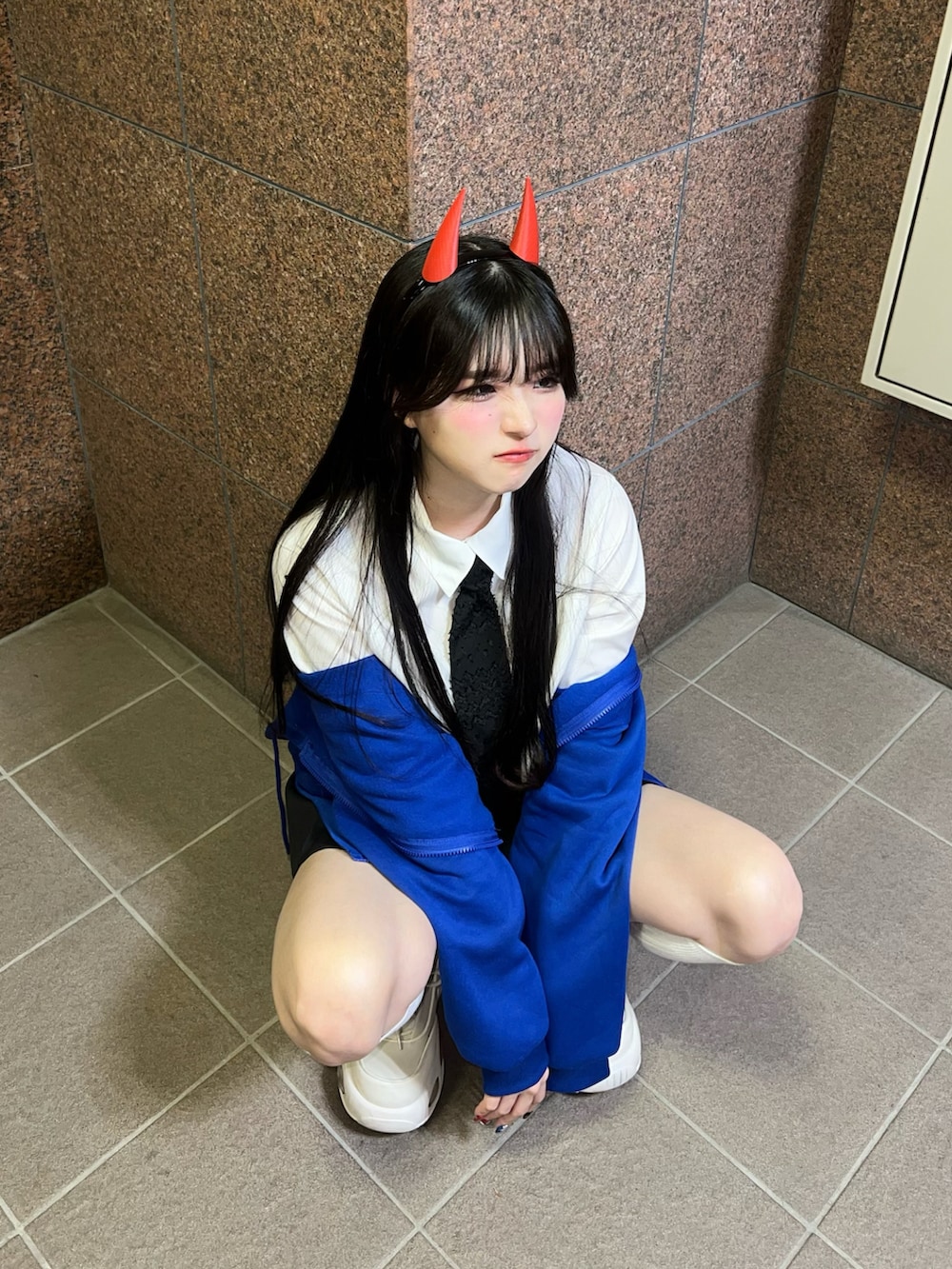 ブラック系のスカート、ブルー系のパーカー、ホワイト系のシャツ/ブラウスを着用したレディースの夏コーディネートの3枚目の写真