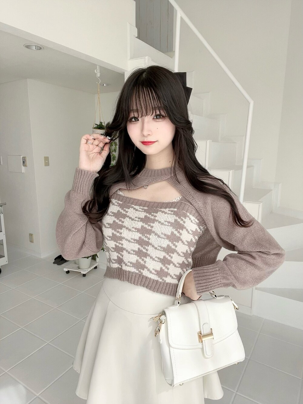 ベージュ系のニット/セーター、ホワイト系のバッグ、ホワイト系のスカートを着用したレディースの秋コーディネートの5枚目の写真