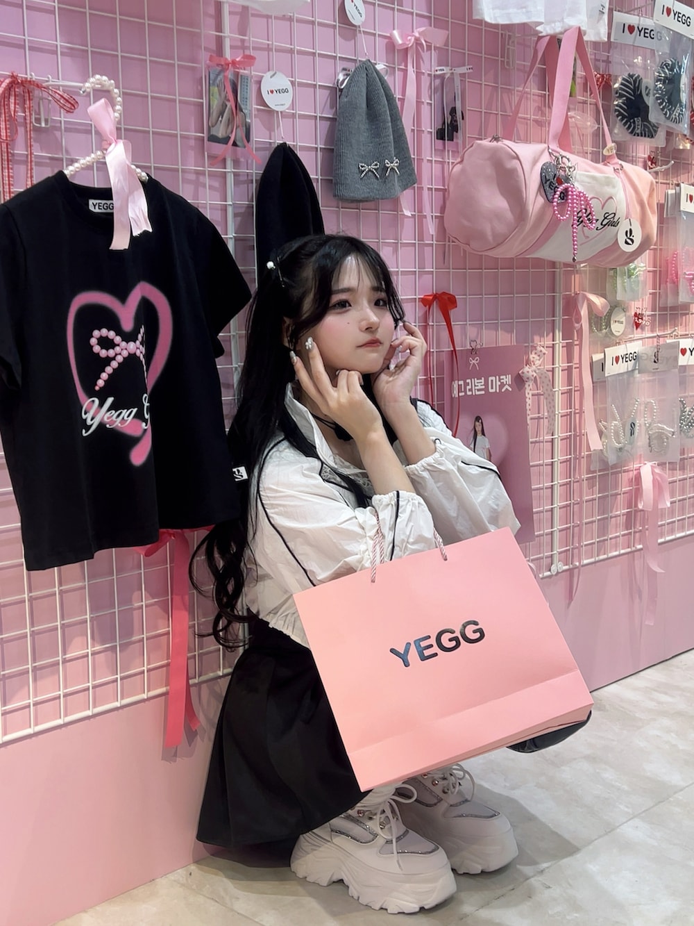 ホワイト系のベスト、ブラック系のスカート、ブラック系のバッグを着用したレディースの夏コーディネートの4枚目の写真