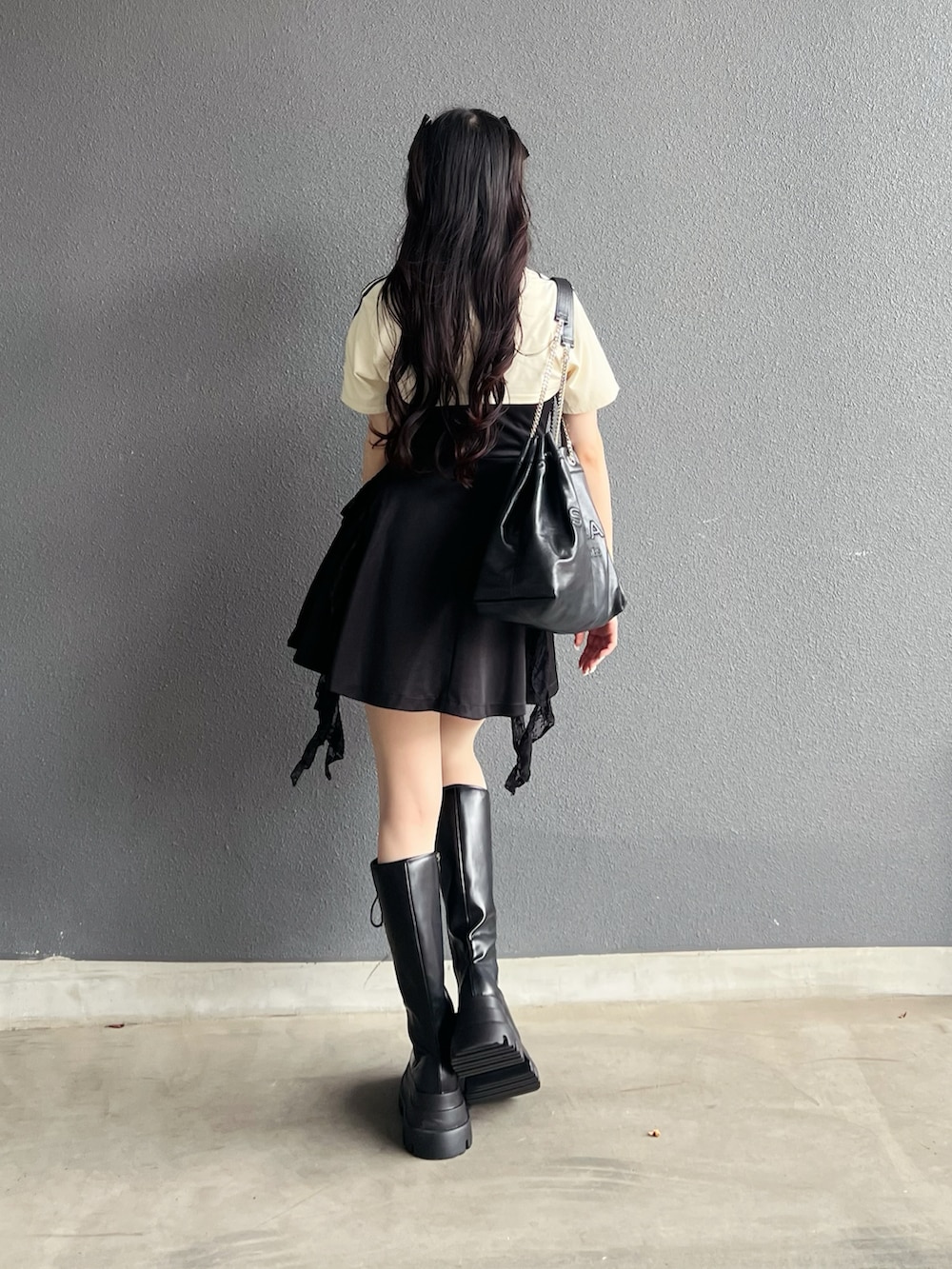 ホワイト系のTシャツ/カットソー、ブラック系のブーツ、ブラック系のショルダーバッグを着用したレディースの夏コーディネートの3枚目の写真