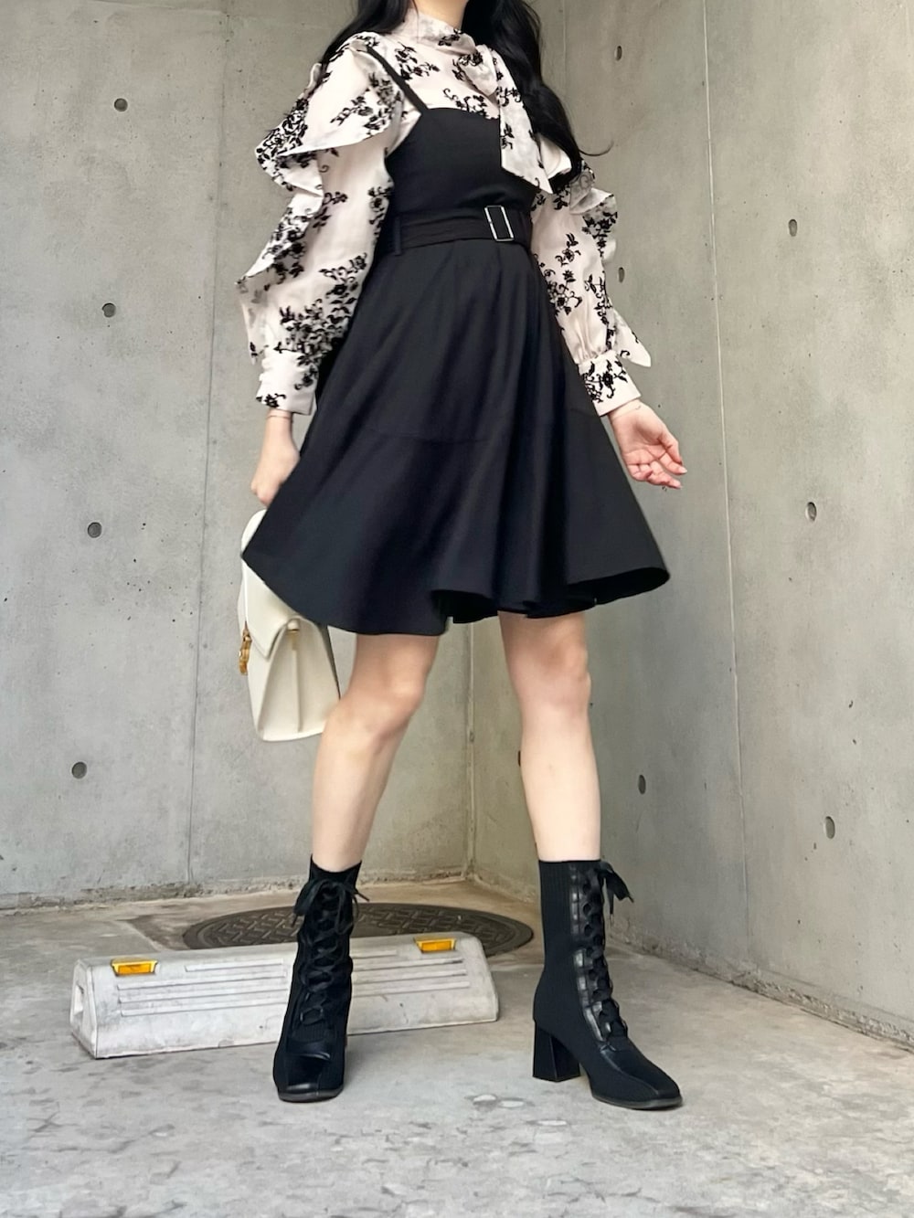 ブラック系のジャンパースカート、ブラック系のシャツ/ブラウス、ブラック系のブーツを着用したレディースの秋コーディネートの3枚目の写真