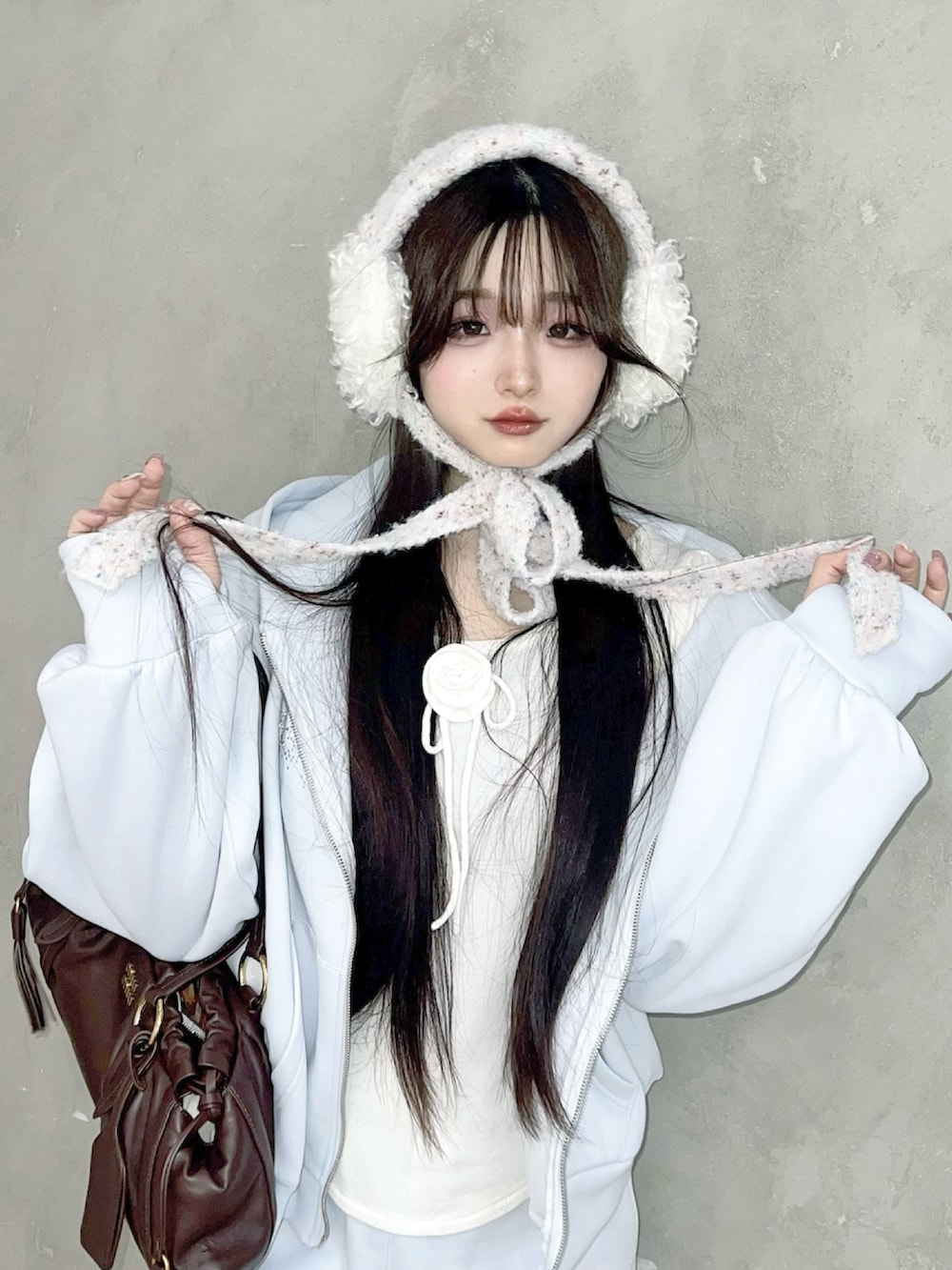 ホワイト系のスニーカー、ブルー系のパーカー、ホワイト系のニット/セーターを着用したレディースの冬コーディネートの2枚目の写真