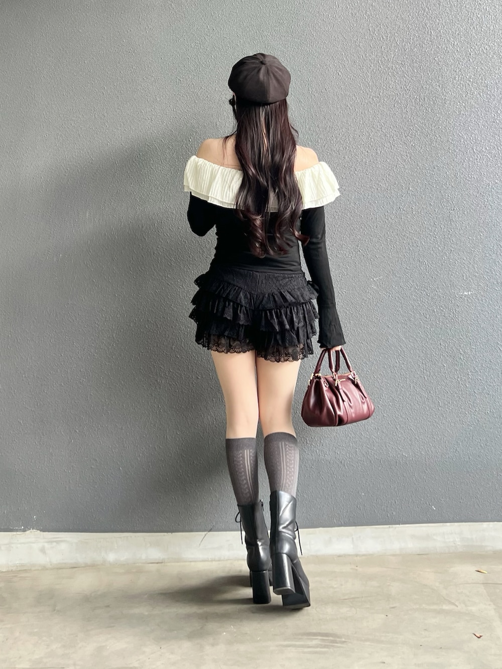 ブラック系のブーツ、ブラック系のトップス、ブラック系のパンツを着用したレディースの秋コーディネートの3枚目の写真