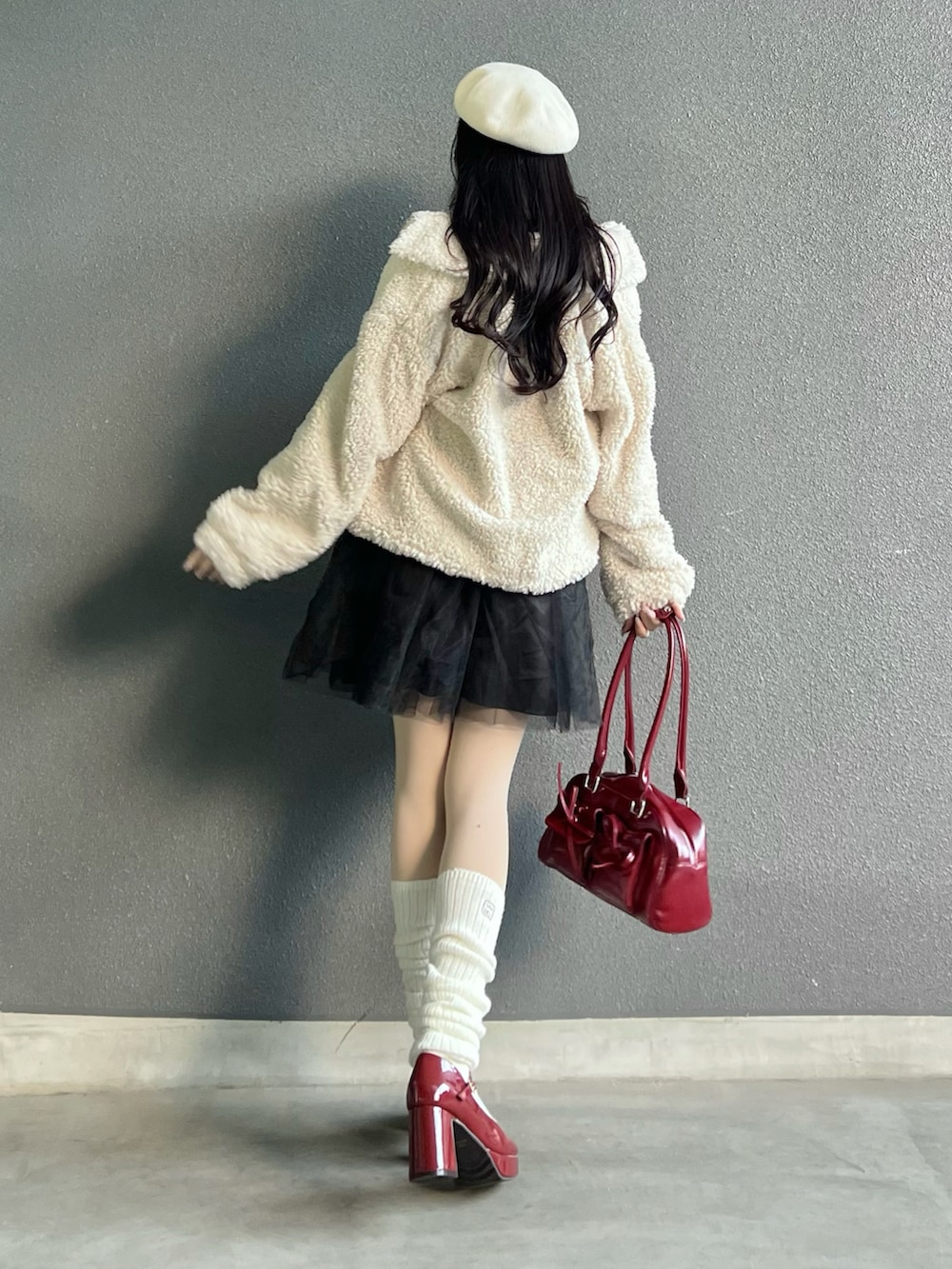レッド系のバッグ、ホワイト系のジャケット/アウター、レッド系のパンプスを着用したレディースの冬コーディネートの3枚目の写真
