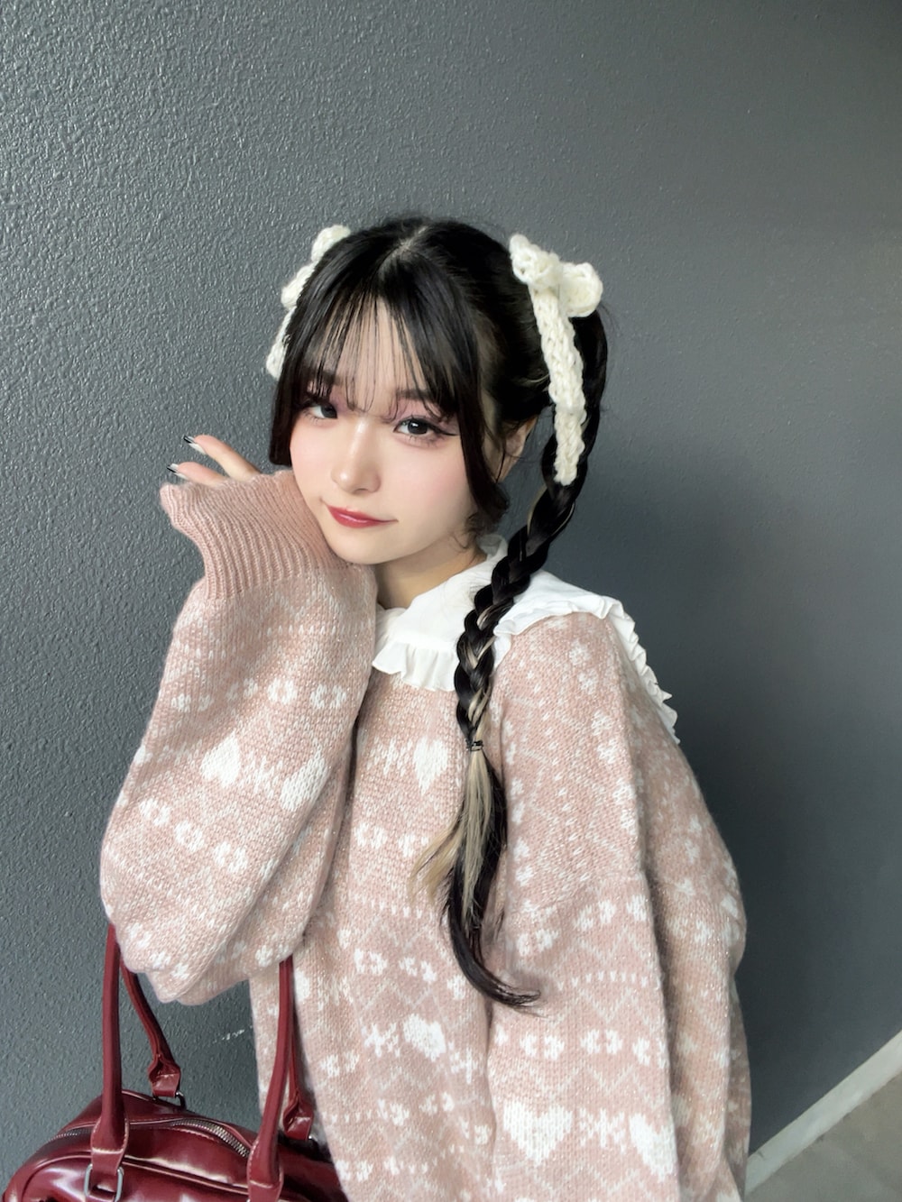 レッド系のバッグ、ブラック系のブーツ、ホワイト系のその他パンツを着用したレディースの秋コーディネートの5枚目の写真