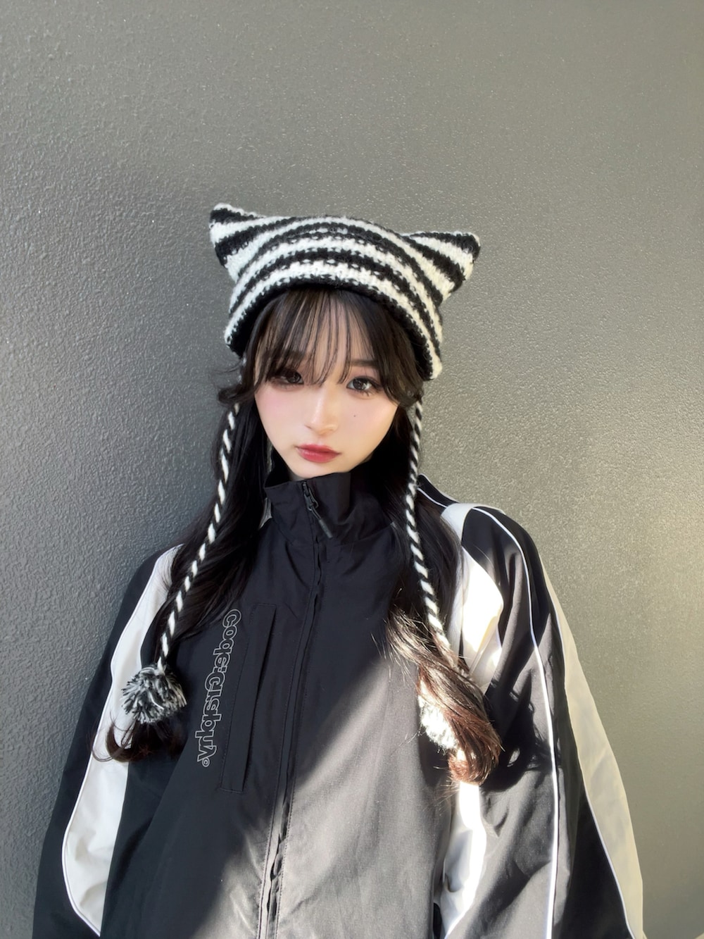 ブラック系のナイロンジャケット、ホワイト系のショルダーバッグ、ホワイト系のシューズを着用したレディースの春コーディネートの5枚目の写真