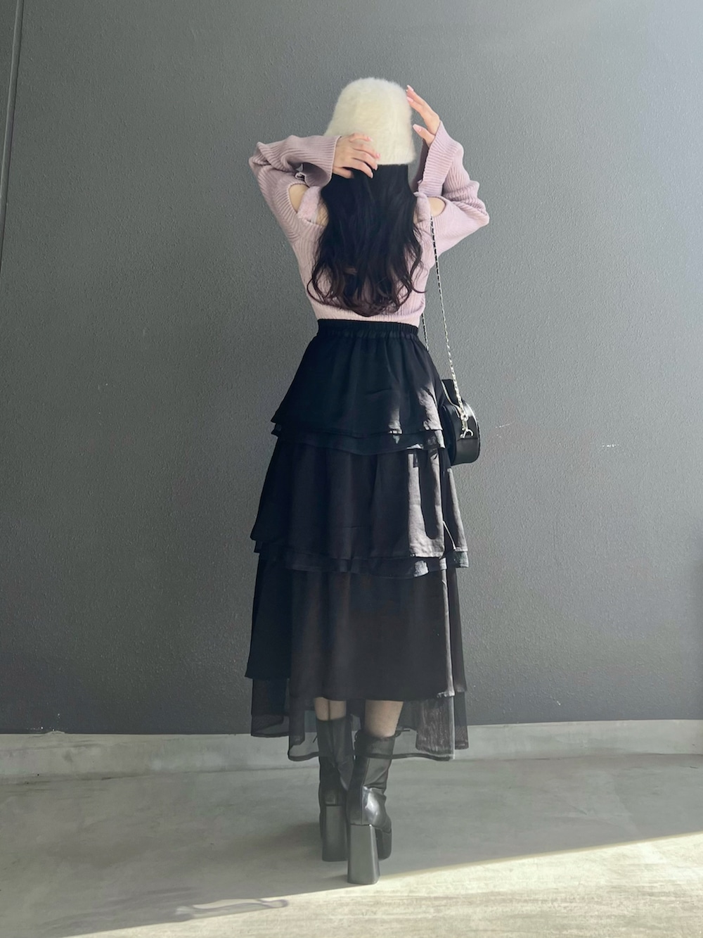 ピンク系のニット/セーター、ブラック系のスカート、ブラック系のブーツを着用したレディースの秋コーディネートの5枚目の写真