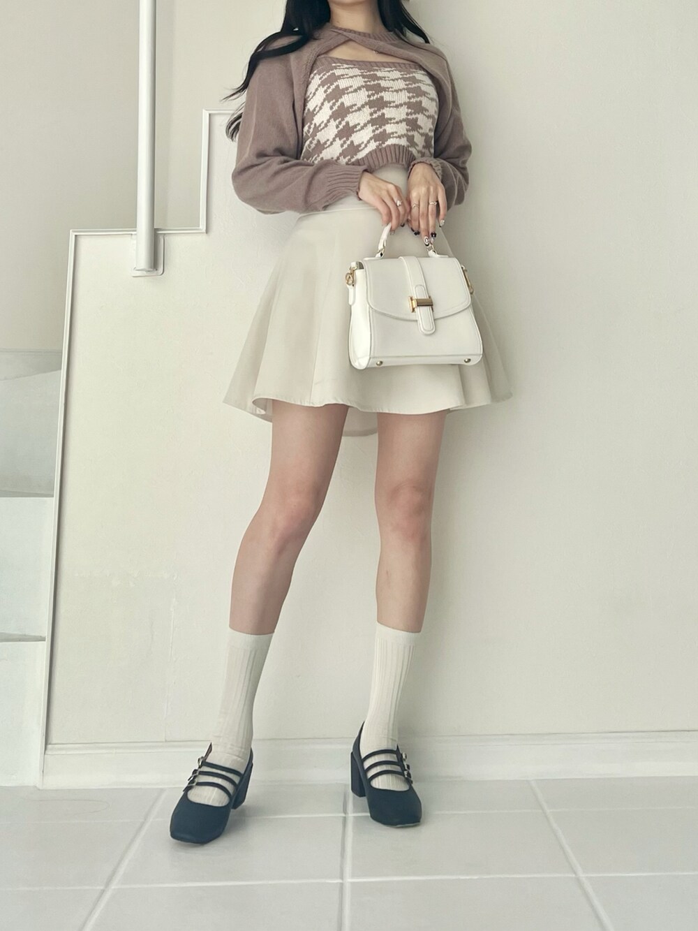 ベージュ系のニット/セーター、ホワイト系のバッグ、ホワイト系のスカートを着用したレディースの秋コーディネートの2枚目の写真