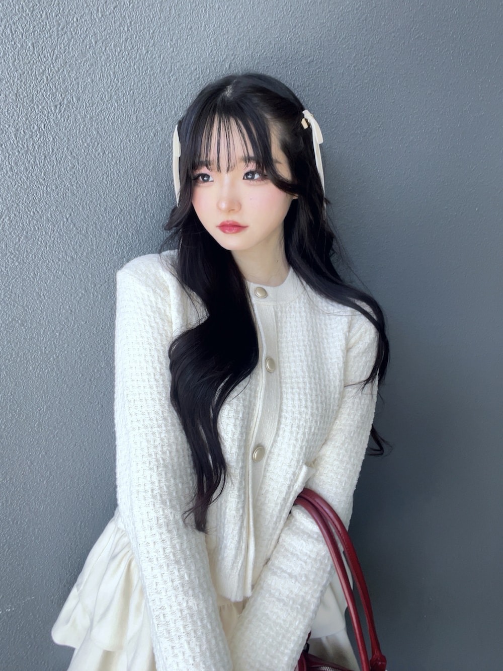 ホワイト系のスカート、ホワイト系のカーディガン/ボレロ、レッド系のパンプスを着用したレディースの秋コーディネートの5枚目の写真