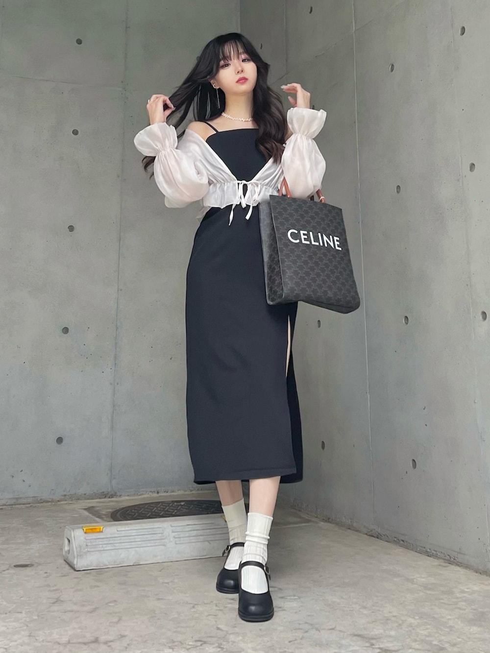 ブラック系のワンピース、ホワイト系のカーディガン/ボレロを着用したレディースの夏コーディネートの2枚目の写真