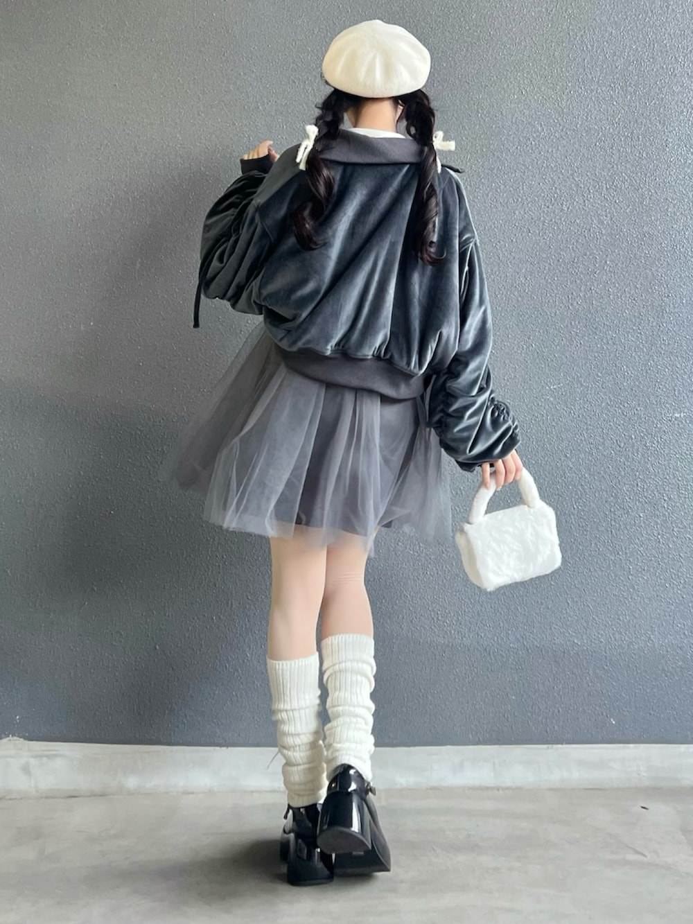 ブラック系のパンプス、グレー系のワンピース、ホワイト系のバッグを着用したレディースの冬コーディネートの4枚目の写真