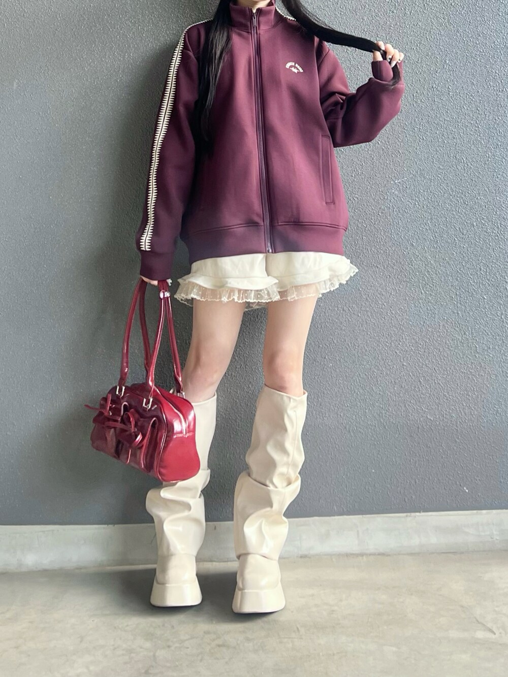 レッド系のジャージ、ホワイト系のその他パンツ、ホワイト系のブーツを着用したレディースの冬コーディネートの3枚目の写真