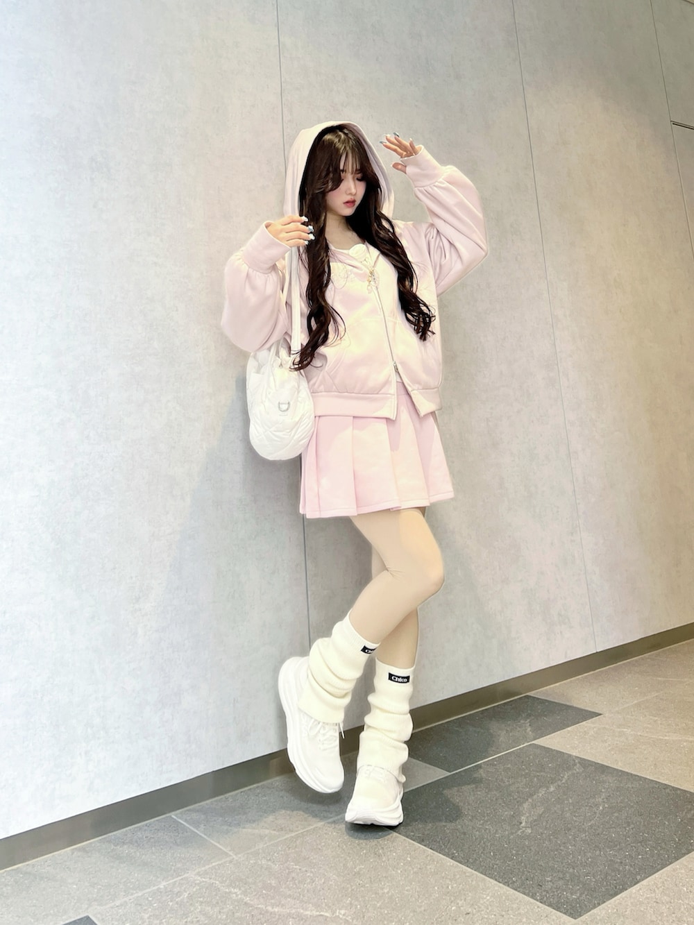 ピンク系のパーカー、ホワイト系のショルダーバッグ、ホワイト系のスニーカーを着用したレディースの春コーディネートの4枚目の写真