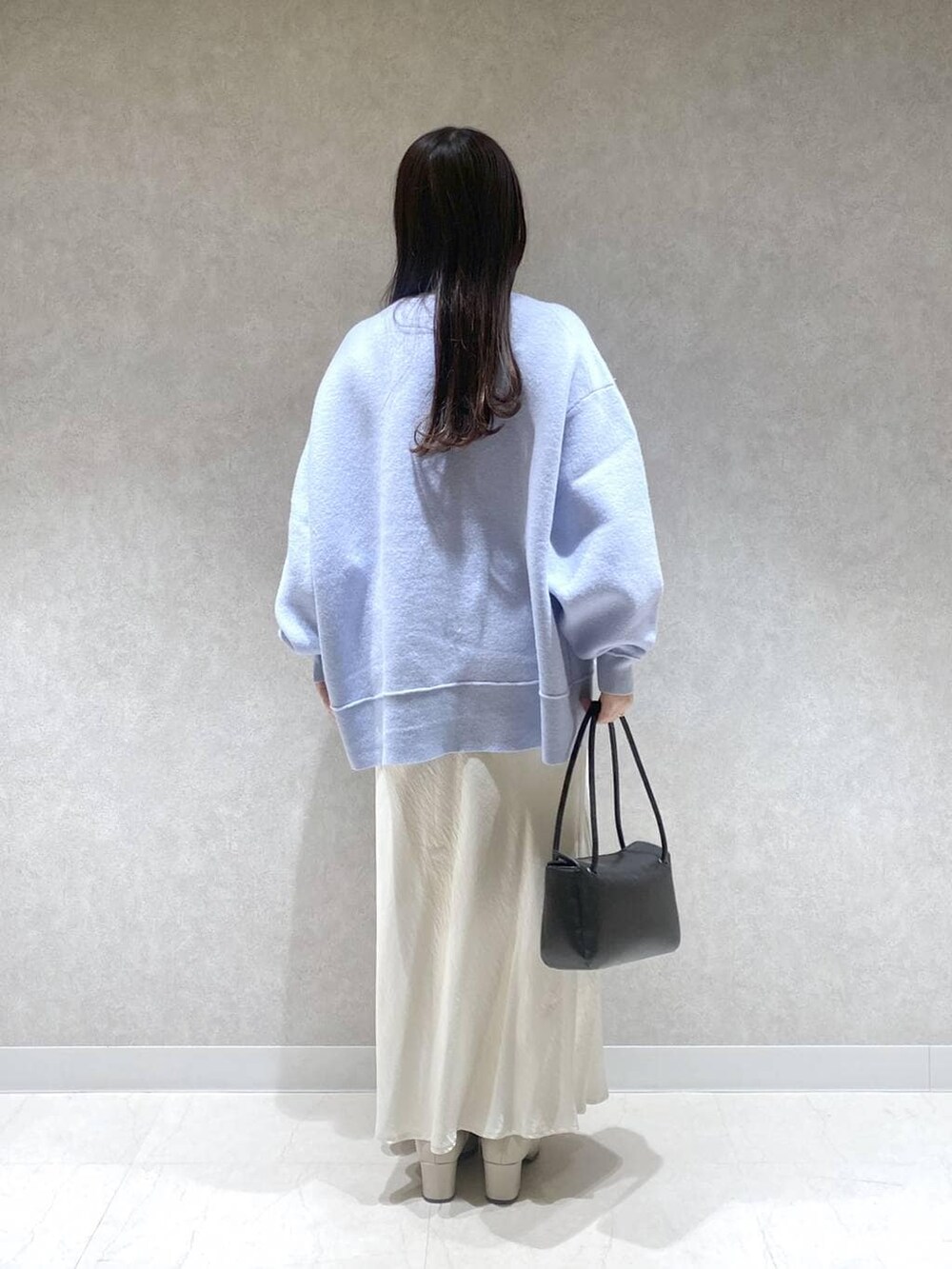 ベージュ系のブーツ、ホワイト系のスカート、ブルー系のニット/セーターを着用したレディースの冬コーディネートの3枚目の写真